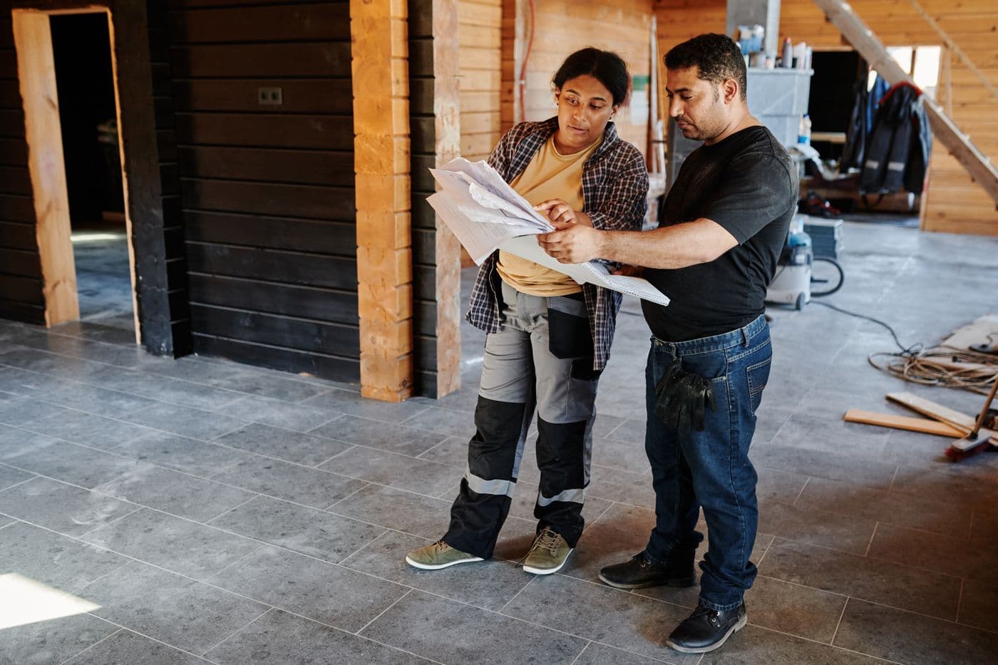 Two people reviewing drawings together on site